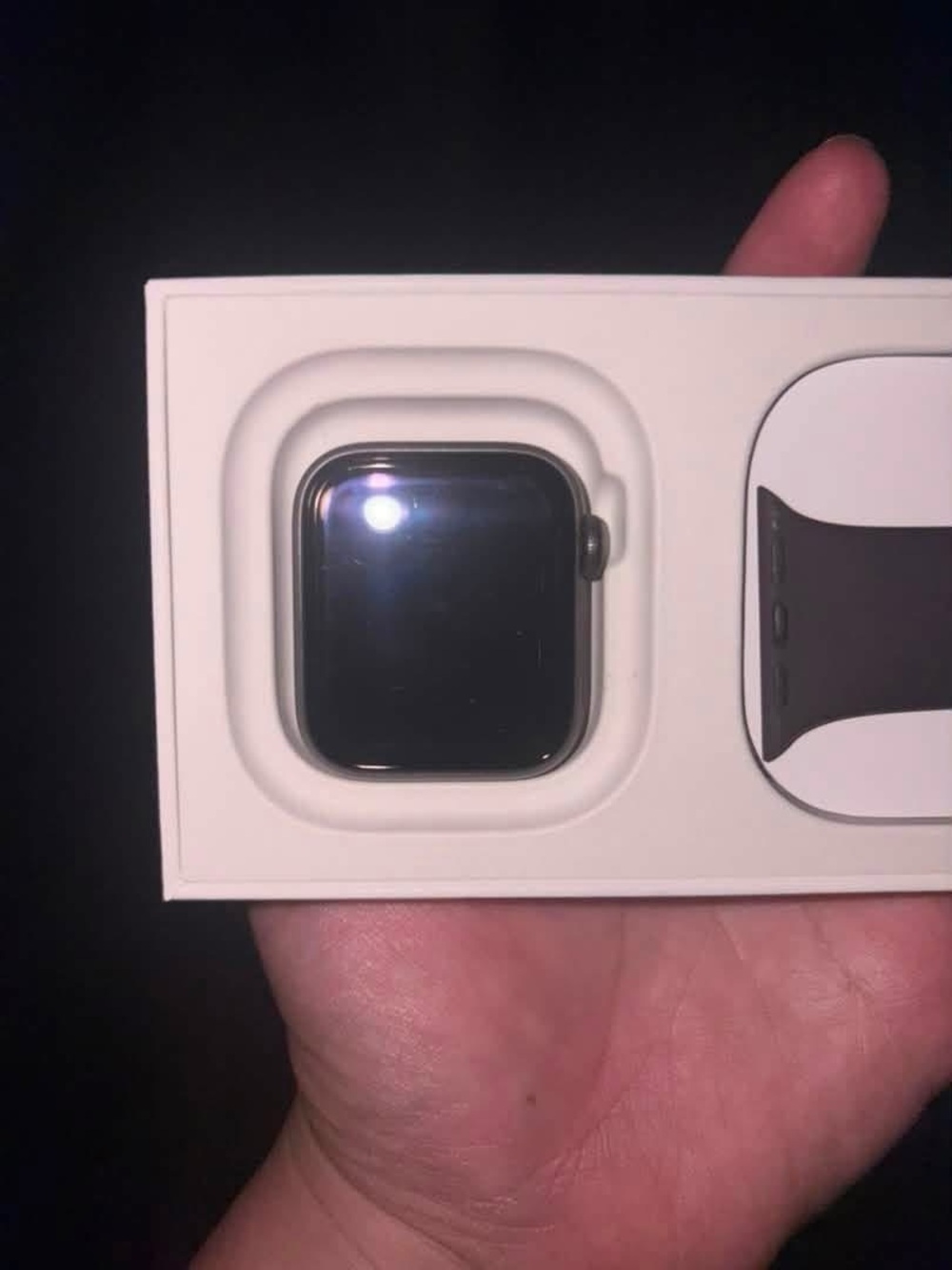 Apple SE GPS watch in grey aluminum case with maroon sports band.